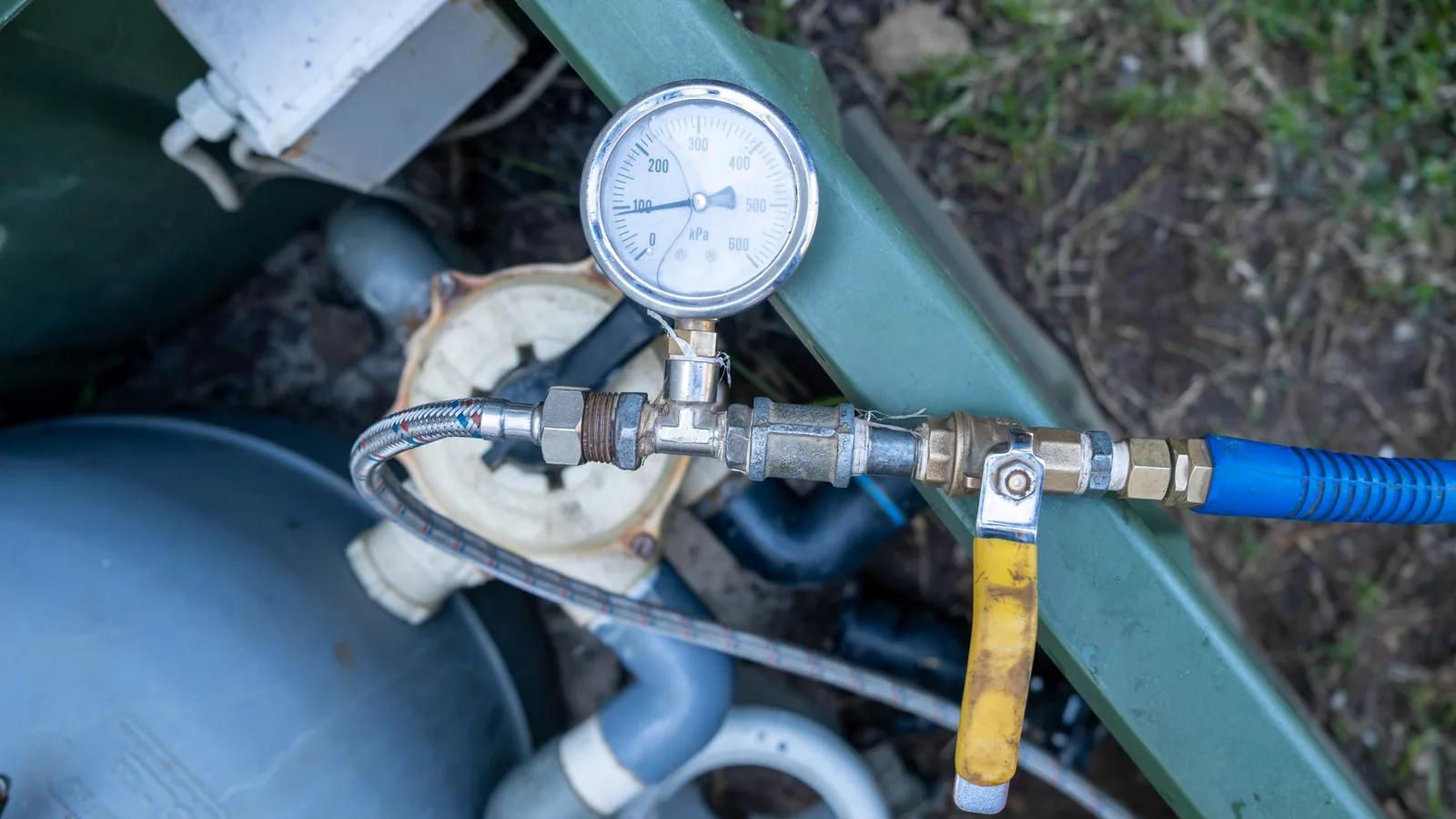 Source Leak Detection technician inspecting pool pump and filter system